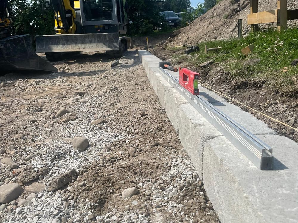 Kantsten sätts med vattenpass vid ett markarbete